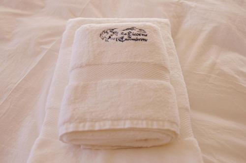 a white towel sitting on top of a bed at La Licorne de l'Encombrette 150 m2 in Allos