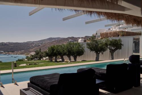 a living room with a couch and a swimming pool at Myconian Villa Collection - Preferred Hotels & Resorts in Elia Beach