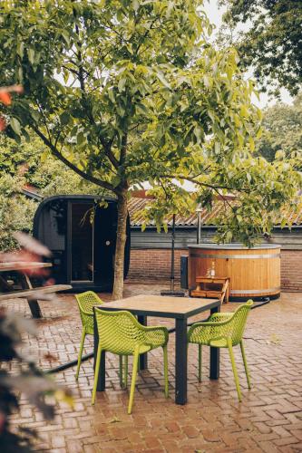 a picnic table and chairs under a tree at Veluwepark de Bosgraaf in Apeldoorn