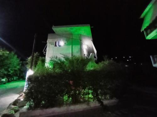 a house with a green light on it at night at Akrata Golden Beach House 2 in Aíyira