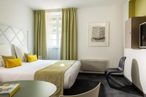 a hotel room with a bed and a table at Villa Diana in Molsheim
