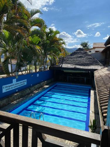 a swimming pool at a resort with palm trees at Pousada Aqui é Para-Ti in Paraty