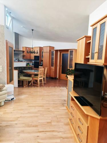 a living room with a kitchen and a dining room at Sternhaus - Appartement am Kurpark in Bad Schallerbach