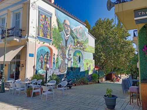 a mural on the side of a building with tables and chairs at Akrata Golden Beach House 2 in Aíyira