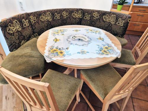 a dining room table with chairs and a plate on it at Sternhaus - Appartement am Kurpark in Bad Schallerbach