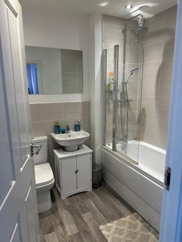 a bathroom with a sink and a toilet and a shower at Tyldesley Manor in Tyldesley