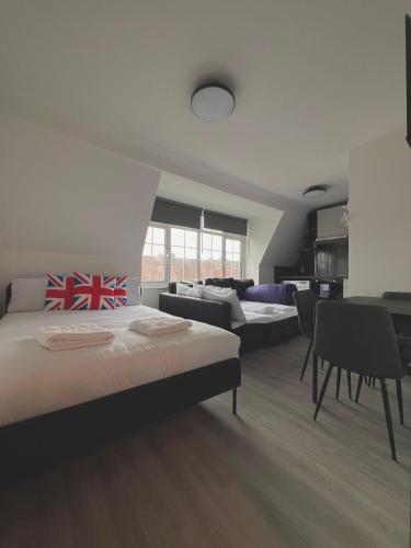 a bedroom with three beds and a table and chairs at Golders Green Studios in London