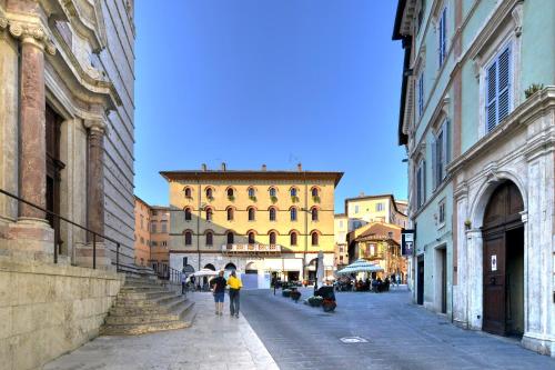 ペルージャにあるNew Era Suite - Duomo di Perugia Centro Storicoの建物が並ぶ通りを歩く人々のグループ