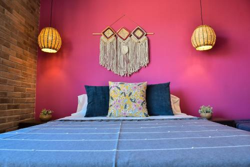 a bedroom with a blue bed with a pink wall at Departamento en Oaxaca para 18 personas - Con amenidades a 2,5km del centro in Oaxaca City