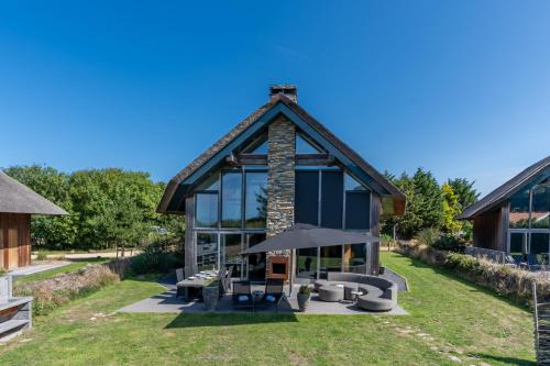 a house with glass walls and a roof at Buytenplaats Villa 183 in De Koog