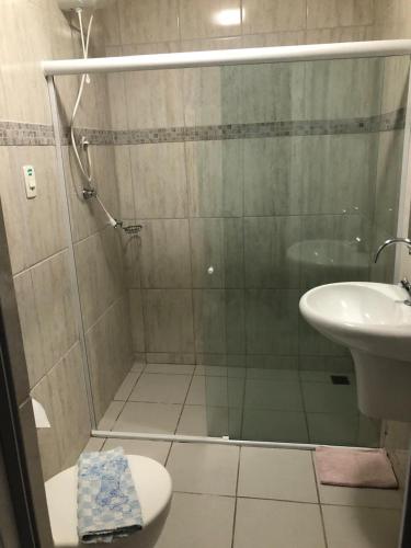 a bathroom with a shower with a toilet and a sink at Pousada Robijn in Cabo de Santo Agostinho