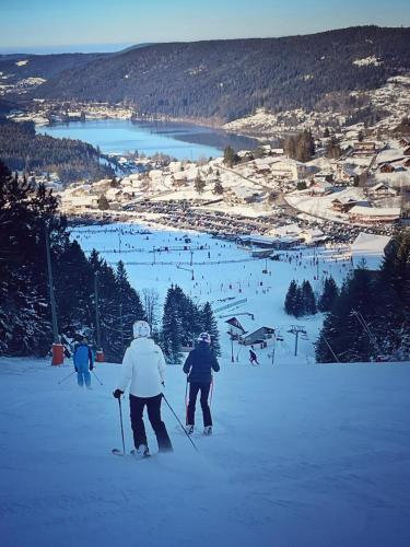 two people on skis in the snow on a ski slope at Le Refuge in Gérardmer