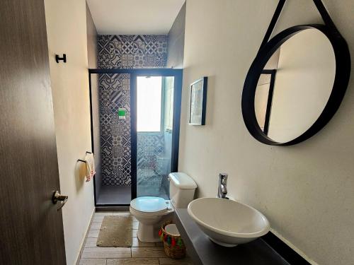 a bathroom with a toilet and a sink and a mirror at Departamento en Oaxaca para 18 personas - Con amenidades a 2,5km del centro in Oaxaca City