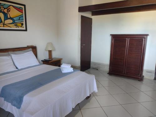 a bedroom with a large bed and a night stand at Pousada Robijn in Cabo de Santo Agostinho