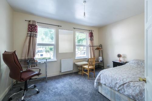1 dormitorio con escritorio, 1 cama y 1 silla en House - Sleeps 8 - Garden - Short Walk to Station, en Londres