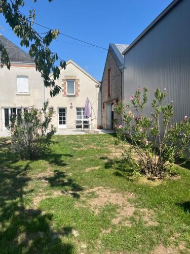 a yard with a house and a building at La petite Maison Mima in Le Champ-sur-Layon
