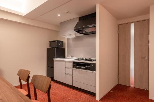 a kitchen with a stove and a table and chairs at Hotel TOKI 季 in Tokyo