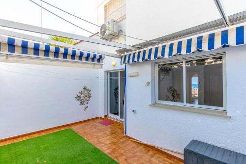 a white building with a window and a lawn at SUENO by the Sea in Dehesa de Campoamor
