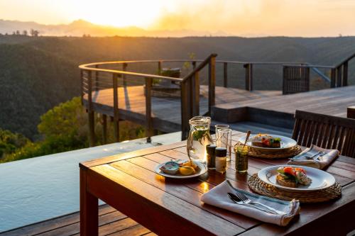 a table with plates of food on top of a deck at Tamodi Estate in Plettenberg Bay