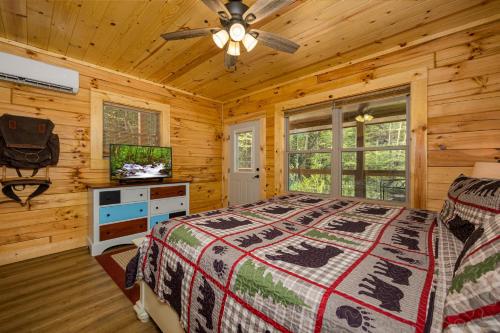 a bedroom with a bed and a flat screen tv at Tridents Creek by American Patriot Getaways in Rocky Grove