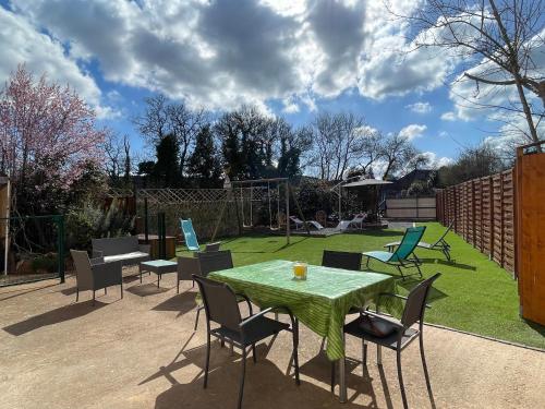 a patio with a table and chairs in a yard at Évasion ensoleillée avec jacuzzi à Cazedarnes in Cazedarnes