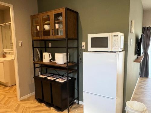 a kitchen with a white refrigerator and a microwave at TOKYO STAY in Kamata in Tokyo