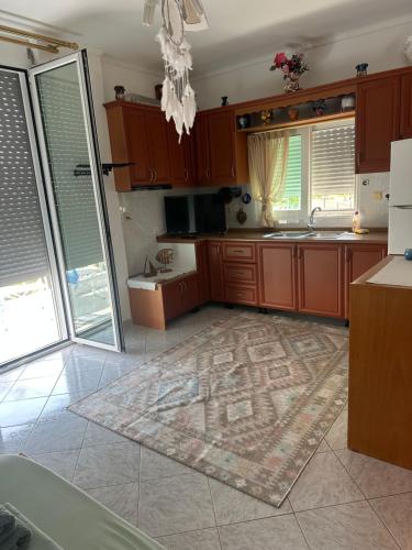 a kitchen with wooden cabinets and a rug on the floor at Joannas Stefaneli House in Himare