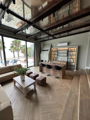 a living room with a couch and a table at Evia Palm Beach Villa in Politiká