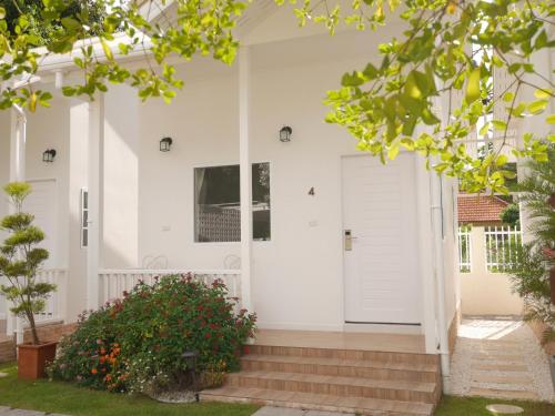 a white front door of a house with stairs at Scholes Hill Khao Yai สกอลส์ ฮิลล์ เขาใหญ่ in Mu Si
