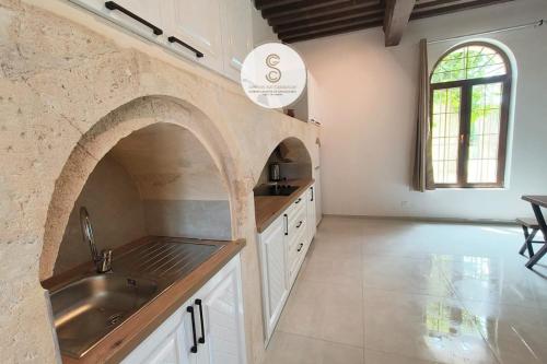 a large kitchen with a sink and an archway at Mas Batelle 2 Arles in Arles