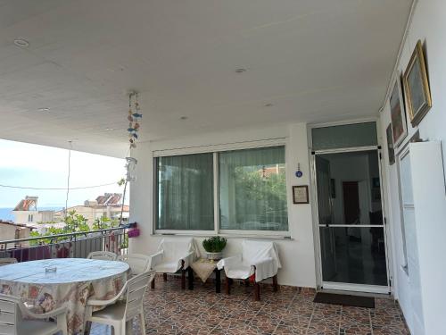 a balcony with tables and chairs and a window at Joannas Stefaneli House in Himare