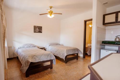 a bedroom with two beds and a ceiling fan at Apart Hotel Explora Tandil in Tandil