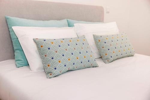 a pile of pillows sitting on top of a bed at Quinta Cerca da Milhera - Unique Experiences by LuxiStay in Ponte da Barca