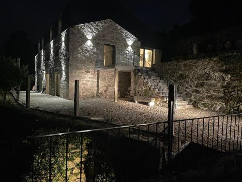 a stone building with lights on it at night at Quinta Cerca da Milhera - Unique Experiences by LuxiStay in Ponte da Barca