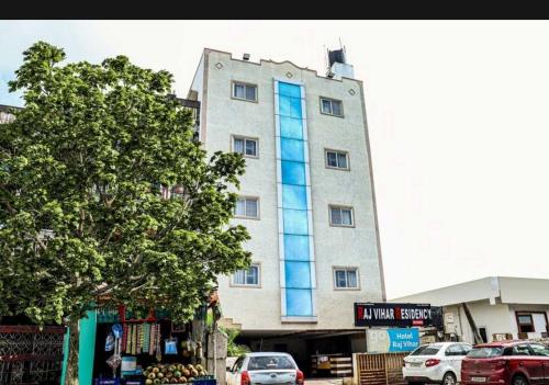 a tall building with blue windows on a street at Hotel O Raj Vihar in Mohammadnagar