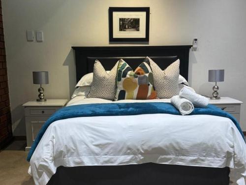 a bedroom with a large bed with pillows at Rivonia Garden Suites in Johannesburg