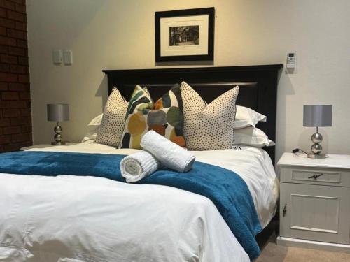 two beds with blue blankets and pillows in a bedroom at Rivonia Garden Suites in Johannesburg