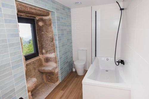 a bathroom with a toilet and a sink and a window at Quinta Cerca da Milhera - Unique Experiences by LuxiStay in Ponte da Barca
