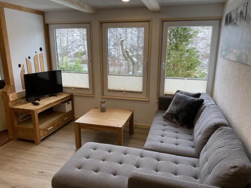 a living room with a couch and two windows at Retreat with Private Garden in Güntersberge