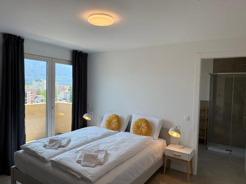 a bedroom with a large bed with a large window at Schloss Locarno - Self Check-In in Locarno