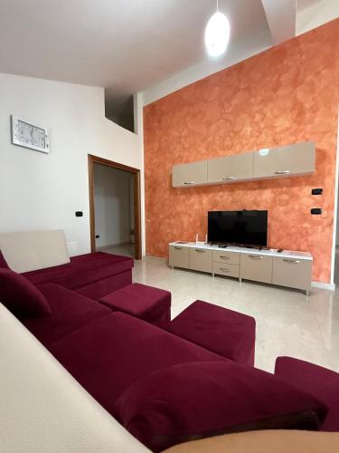 a living room with red couches and a flat screen tv at Villa Gjoni in Kalmet