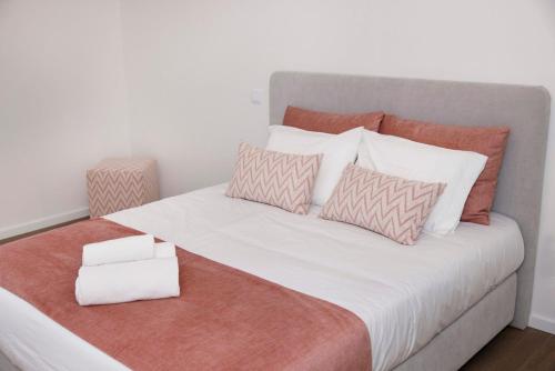 a large bed with pillows on it with a white at Quinta Cerca da Milhera - Unique Experiences by LuxiStay in Ponte da Barca