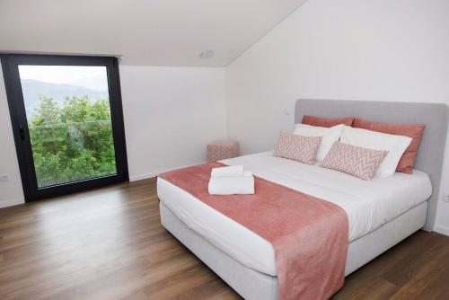 a bedroom with a large bed with a window at Quinta Cerca da Milhera - Unique Experiences by LuxiStay in Ponte da Barca