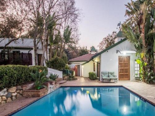 a swimming pool in front of a house at Rivonia Garden Suites in Johannesburg