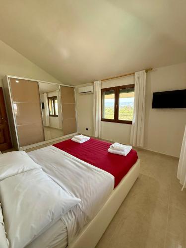 a bedroom with a large bed with a red blanket at Villa Gjoni in Kalmet
