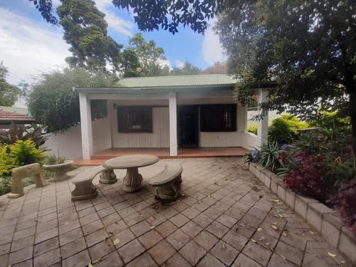 a patio with a table and benches in front of a building at Rivonia Garden Suites in Johannesburg