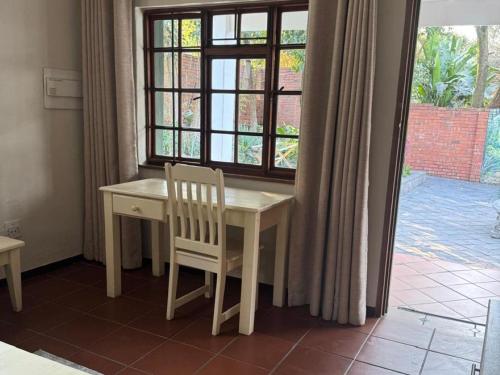 a table and chair in a room with a window at Rivonia Garden Suites in Johannesburg