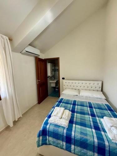 a bedroom with a blue and white bed with two towels at Villa Gjoni in Kalmet