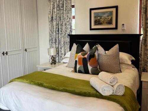 a bedroom with a large bed with towels on it at Rivonia Garden Suites in Johannesburg