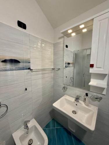 a white bathroom with two sinks and a mirror at Villa Gjoni in Kalmet